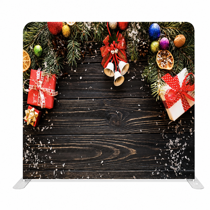 Christmas backdrop with festive gifts and bells on wooden background