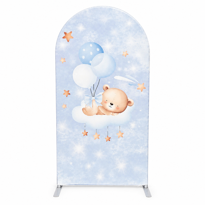 Blue side of gender reveal arch backdrop featuring teddy bear with balloons