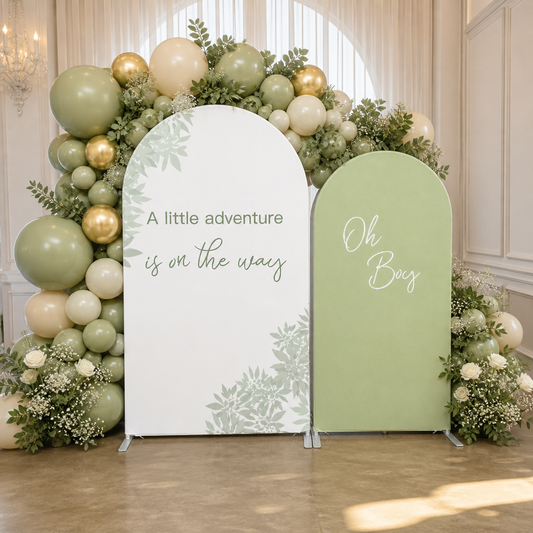 Green botanical arch backdrop set with balloon decorations in a white room