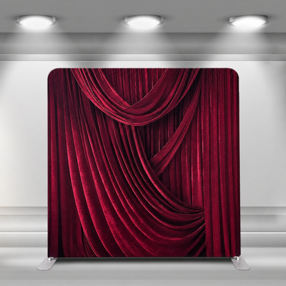 Velvet red draped curtain backdrop in studio setting under spotlight