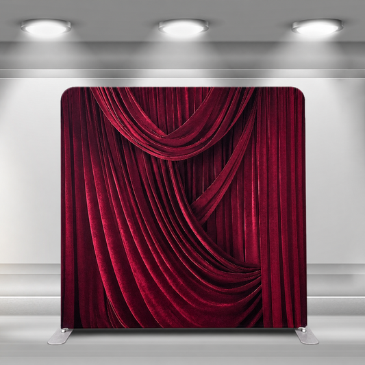Velvet red draped curtain backdrop in studio setting under spotlight