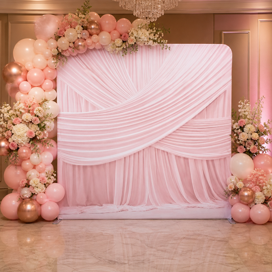 Pink draped fabric backdrop decorated with balloons and flowers