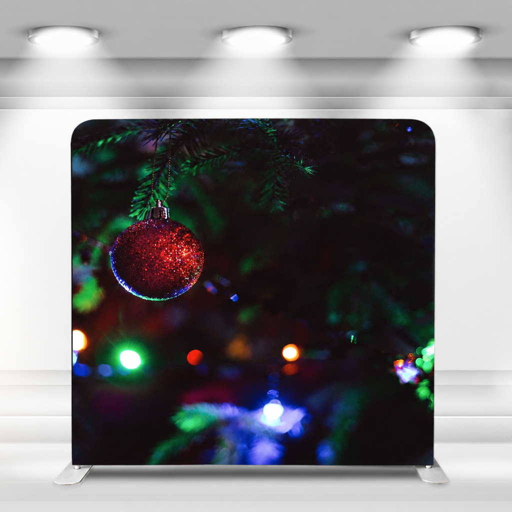 Christmas themed tension fabric backdrop with ornament and lights indoors