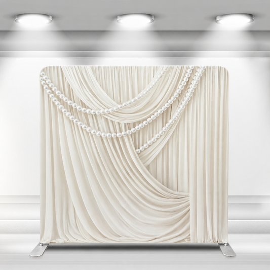 Ivory draped fabric backdrop with pearl strand accents on stand