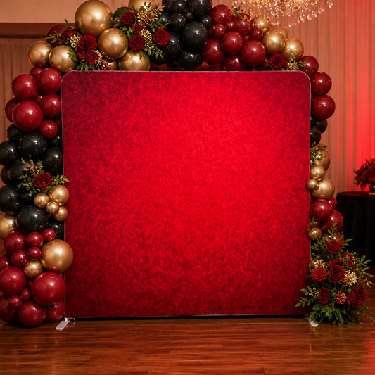 Red fabric backdrop decorated at event with balloon arch and flowers